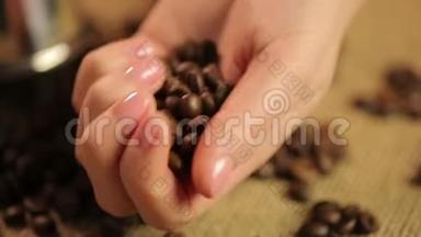 女人的手抚摸着烤咖啡豆，准备享受<strong>浓浓</strong>的味道